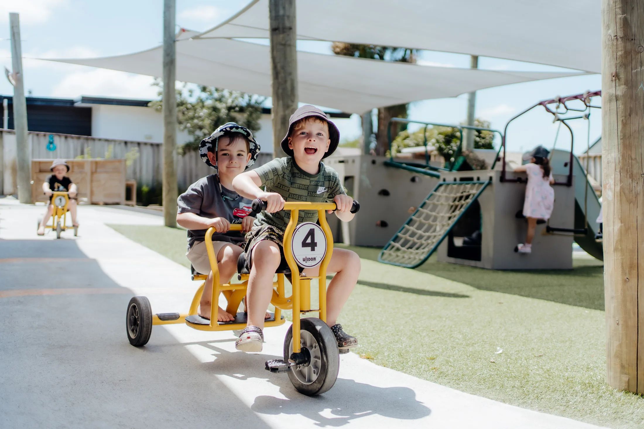 Children riding bikes together in the Tiny Legends outdoor space